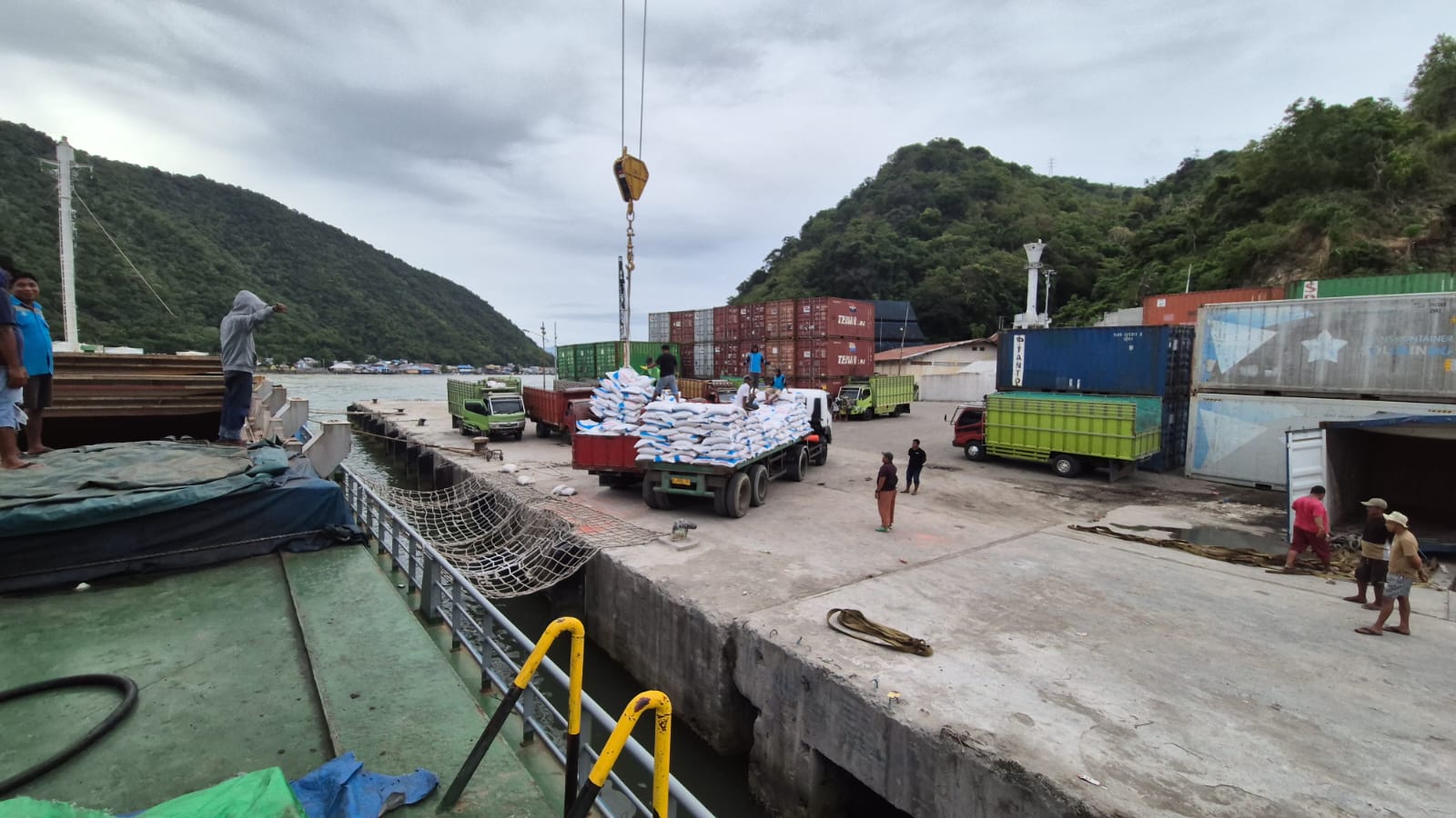 Kegiatan bongkar muat kargo dari kapal ke truk di area pelabuhan
